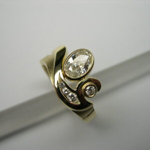 Anell d’or groc amb diamant talla oval i diamants talla brillant
