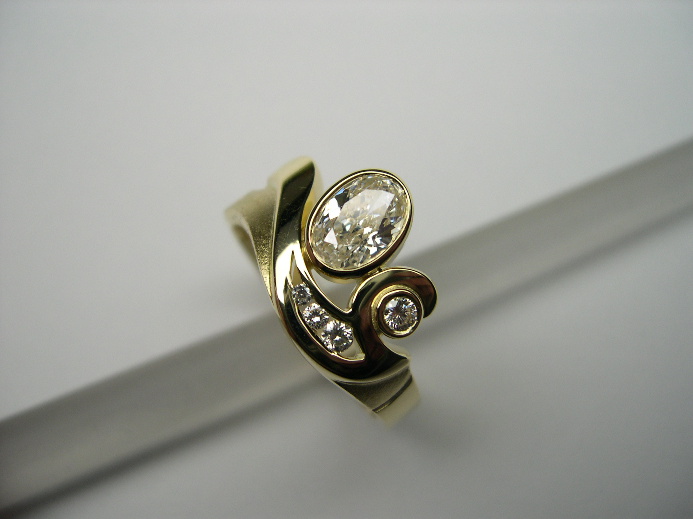 Anell d’or groc amb diamant talla oval i diamants talla brillant
